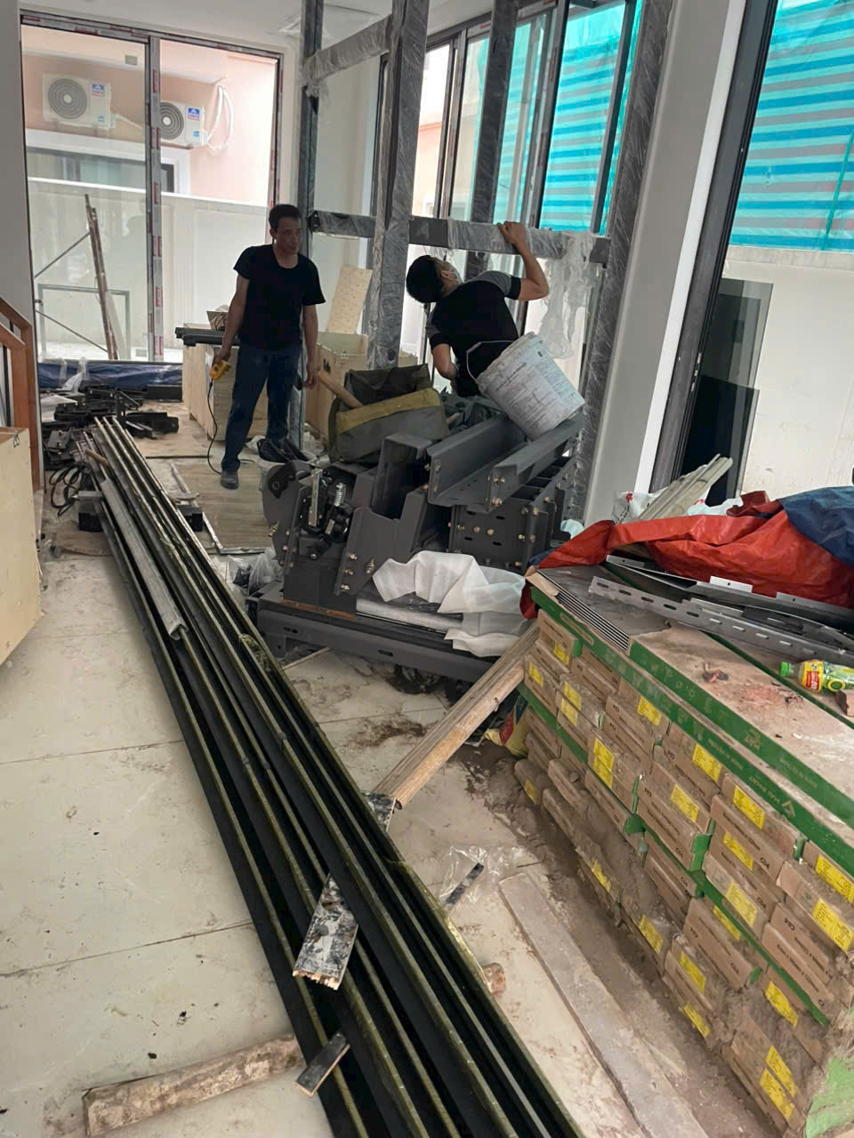Thi công lắp đặt thang máy gia đình với khung ray dẫn hướng và thiết bị máy kéo trong nhà đang xây dựng